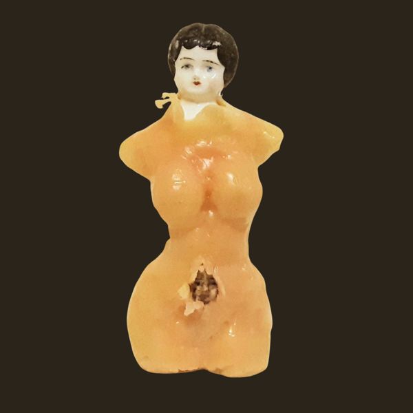 Vessel. A small torso with a porcelain doll's head, an opening worn into its middle where a child's doll head peeks out.